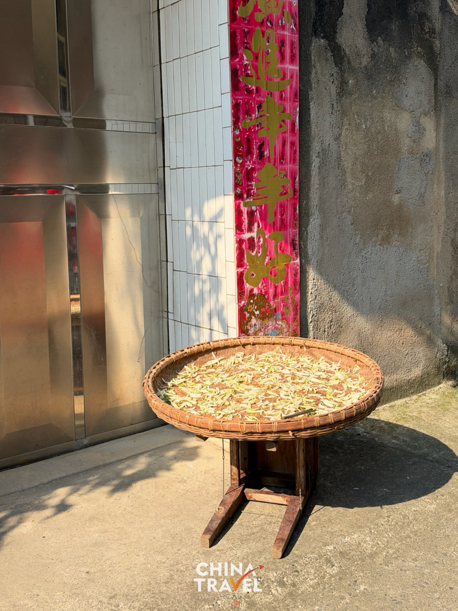 Fresh local produce spread out to dry in the sun outside a doorway. /CGTN