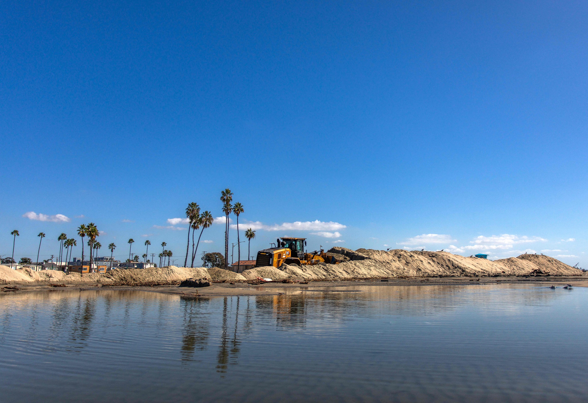 A front loader is used to build a sand berm as preparations are underway for unusually high tides and coastal flooding in Long Beach, California, US, October 27, 2026. /VCG
