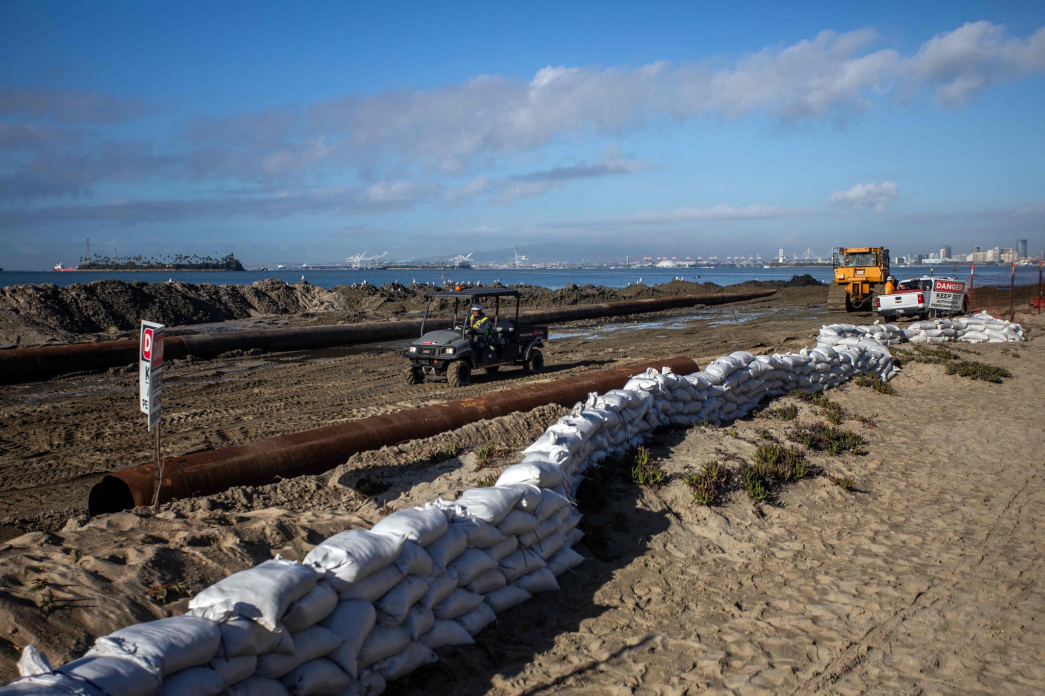 Workers build a sand berm as preparations are underway for unusually high tides and coastal flooding in Long Beach, California, October 27, 2026. /VCG