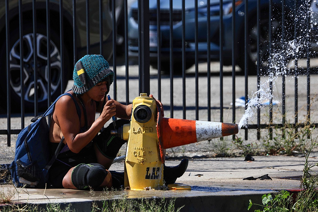 An unhoused person opens a fire hydrant during an extreme heat warning in Los Angeles, California, US, on October 6, 2026. /VCG