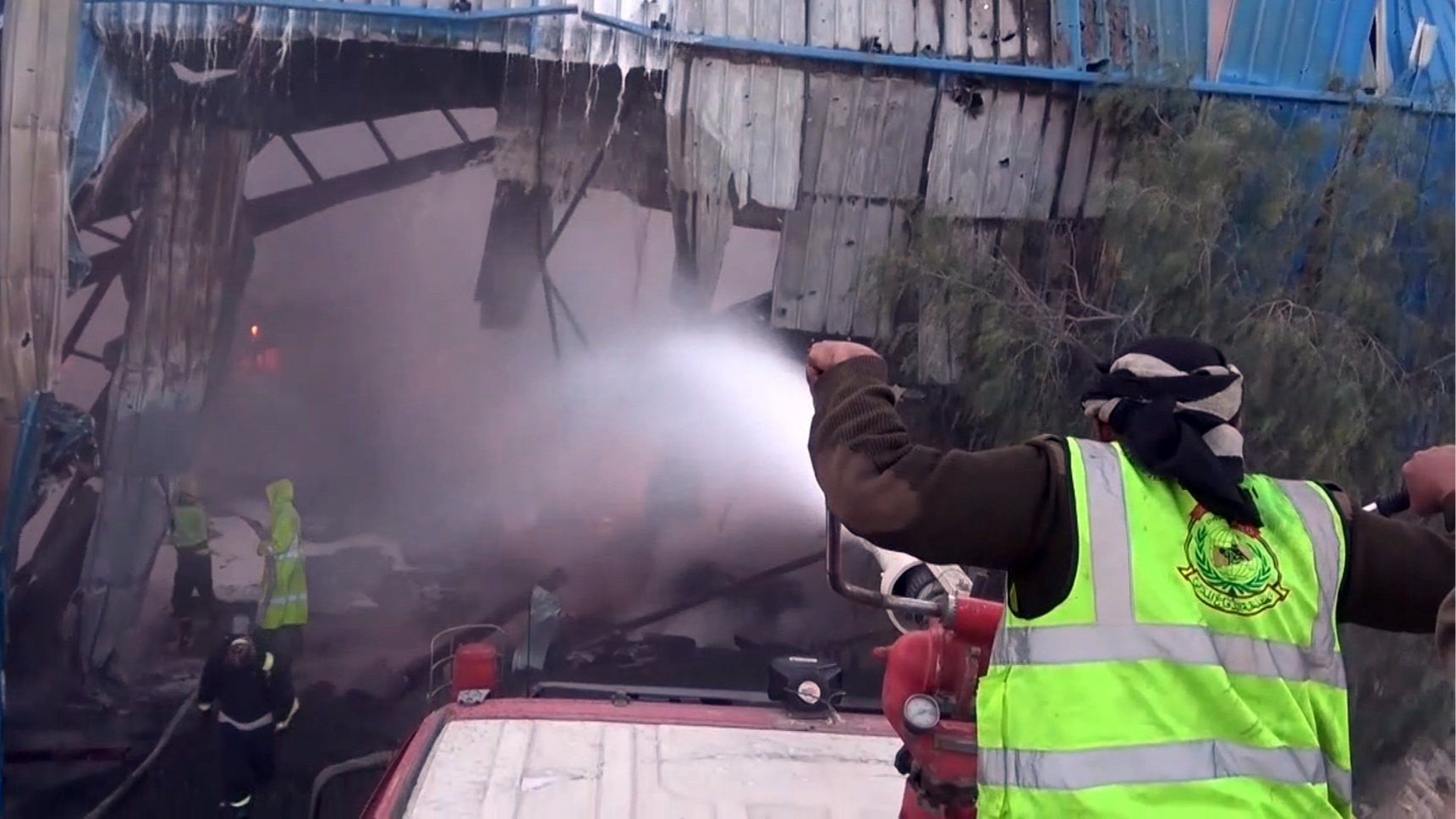 A screenshot from a video made available by Houthi-run Al-Masirah TV shows firefighters extinguishing a fire after alleged Saudi-led airstrikes targeted a cement plant on the outskirts of Sanaa, Yemen, October 27, 2026. /VCG