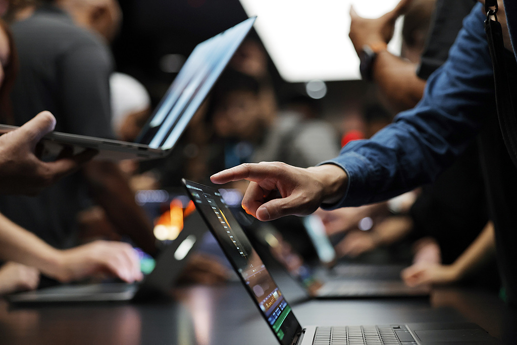 Attendees try the new touchscreen MacBook Pro at the Apple 