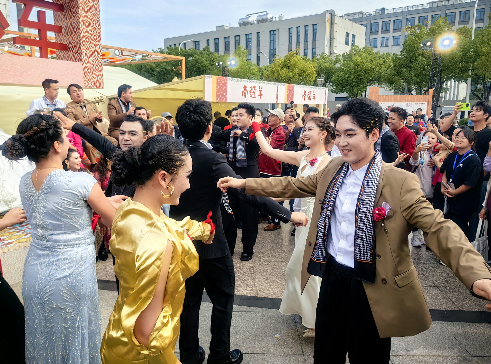 People dance and sing during the 2026 Shanghai-Xinjiang Cultural Exchange Week event in Zhoupu Town, Shanghai on October 29, 2026. /VCG
