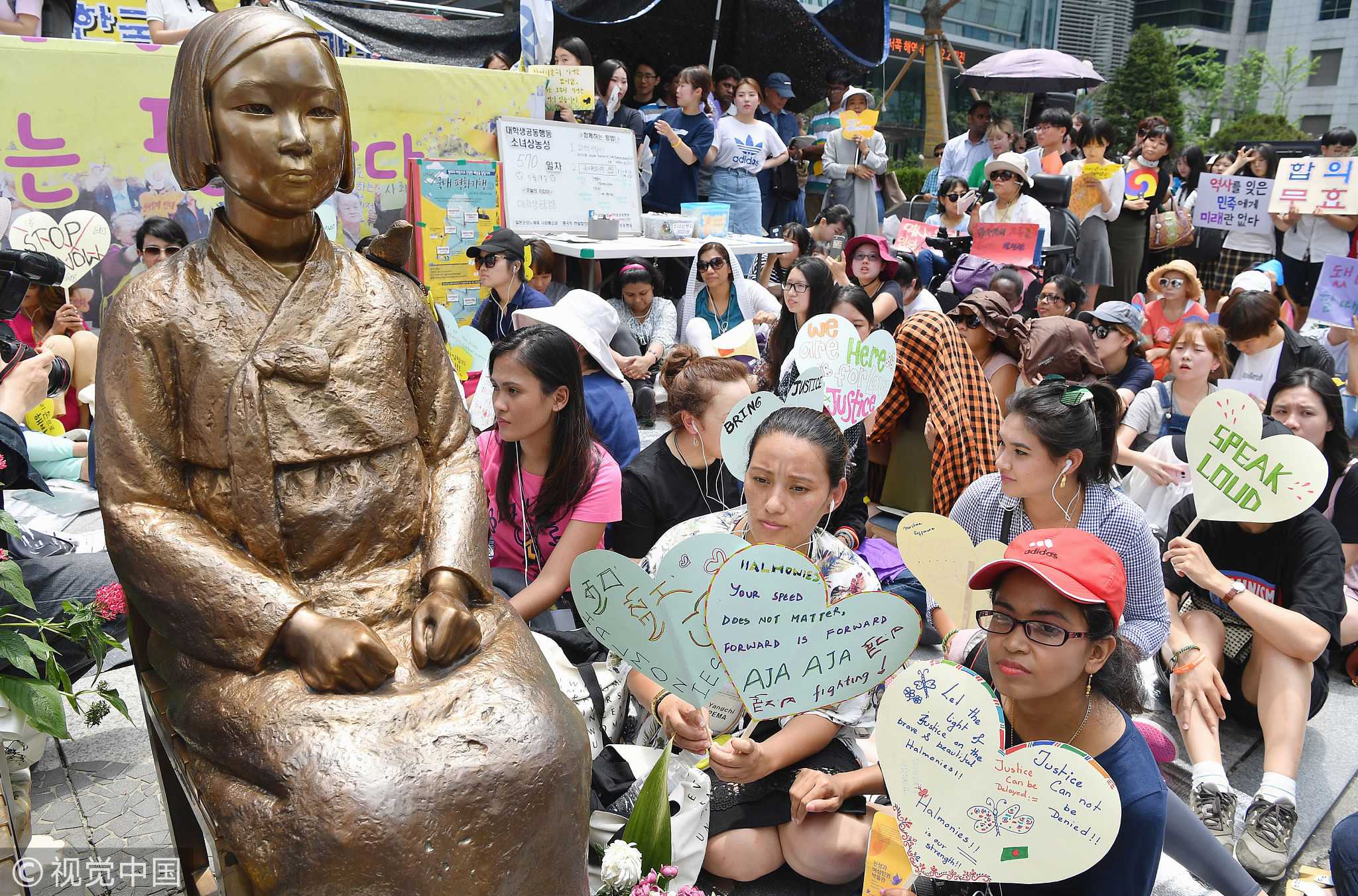 People gather for a rally next a statue of a 'comfort woman' in f...