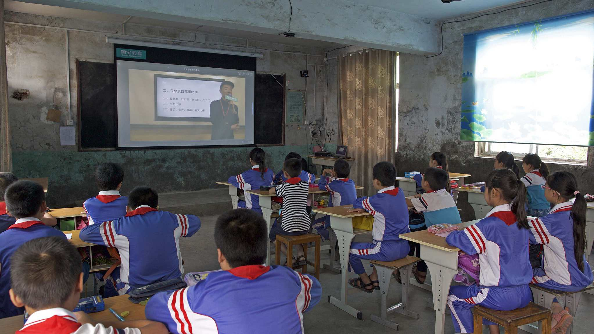 Students in rural communities learning through a screen projector