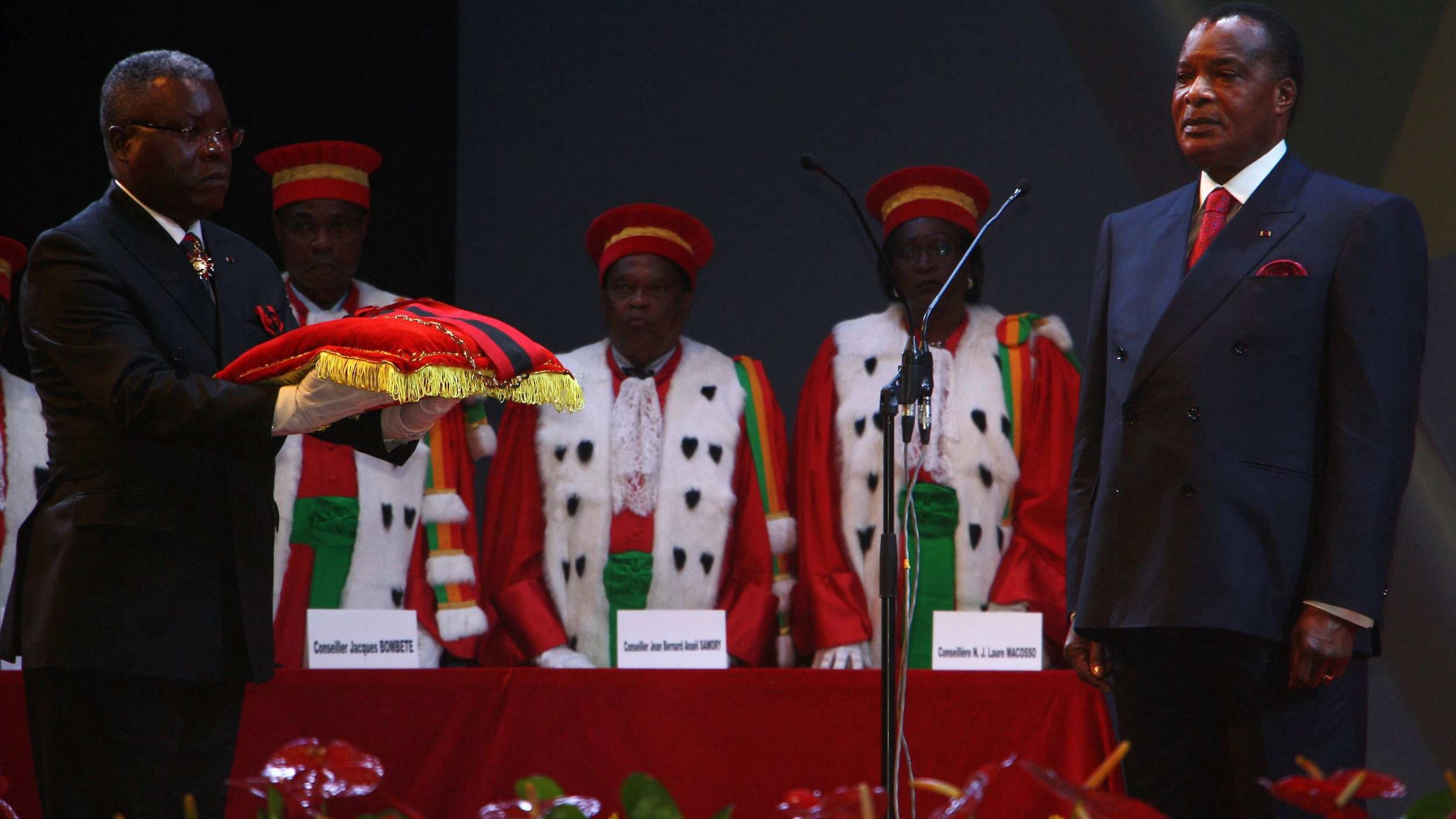 Congolese President Denis Sassou Nguesso (R) receives the insignia of the p...